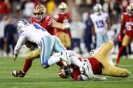 Nick Bosa and Samson Ebukam of the San Francisco 49ers tackle Dak Prescott of the Dallas Cowboys during the fourth quarter in the NFC Divisional Playoff game